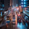 The Trams in the Rain artwork captures a bustling city street at night, where double-decker buses and trams traverse rain-slick roads. Neon signs in different languages illuminate the scene, creating vibrant reflections on wet pavement, with towering buildings adding depth to the urban tableau.