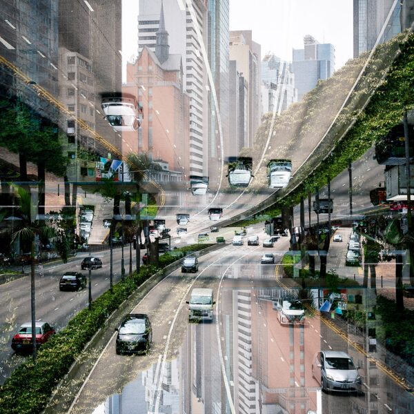The Möbius City art print showcases a surreal, mirrored cityscape where streets and buildings twist in an abstract manner. Cars navigate these bending roads, creating a kaleidoscopic effect with urban architecture and greenery.