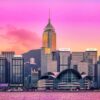 The Purple City art print beautifully captures Hong Kongs iconic skyline at sunset, with modern skyscrapers reflecting pink and orange hues. Distinctive architecture graces the waterfront, set against a mountainous backdrop, creating a stunning visual masterpiece.