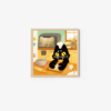 The art print Baking Time! shows a cute black cat in a chefs hat on a kitchen counter nibbling a bread roll, surrounded by baking supplies like flour, a rolling pin, and a mixing bowl, with an oven in the background.