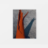 The product Break resembles a damaged red traffic cone on a gray asphalt road, casting a striking shadow like an abstract art print, with cracked jagged edges and missing pieces indicating damage or wear.