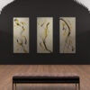 The Utopia abstract art prints, with fluid curves and colorful dots in black, orange, and yellow tones, are showcased on a dark wall. A cushioned bench rests on the wooden floor in front of the artwork.