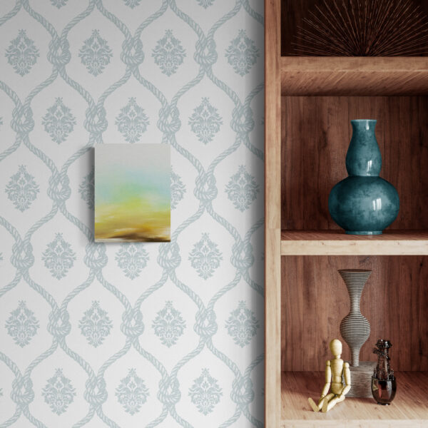 The wooden shelf displays a blue vase, glass vase, wooden mannequin, and small decorative item. On the adjacent wall, an art print complements the patterned wallpaper and features Pure, a small abstract painting with vibrant green and yellow hues.